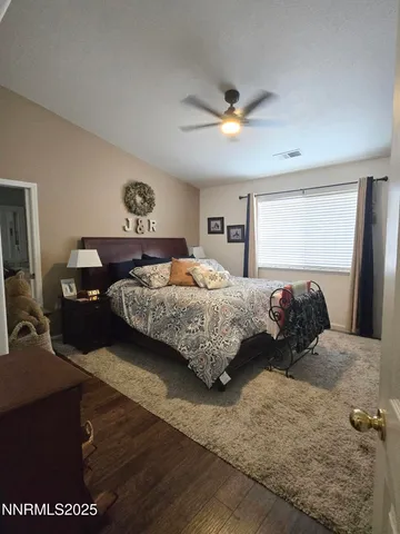 a bedroom with a bed and a dresser with rug