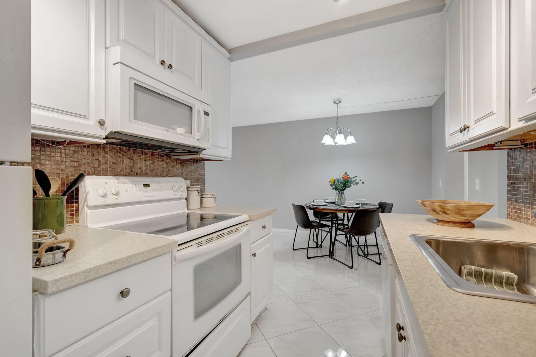 3031 Cornwall East Boca Raton, FL 33434 - Photo 10 of 84 a kitchen with a stove a sink and a microwave