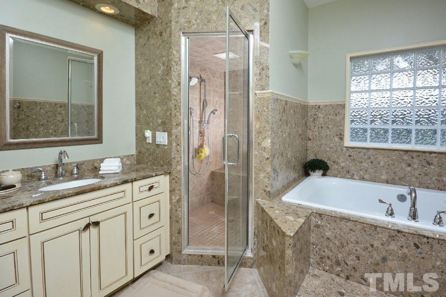 7016 Holly Ridge Road Rougemont, NC 27572 - Photo 14 of 24 The luxurious master bath has rich green-hued granite counters and surrounds, a large whirlpool tub, separate commode room, an oversize tiled shower with bench seating, and a steam shower. Naturally light filled by a glass block window and sky light.