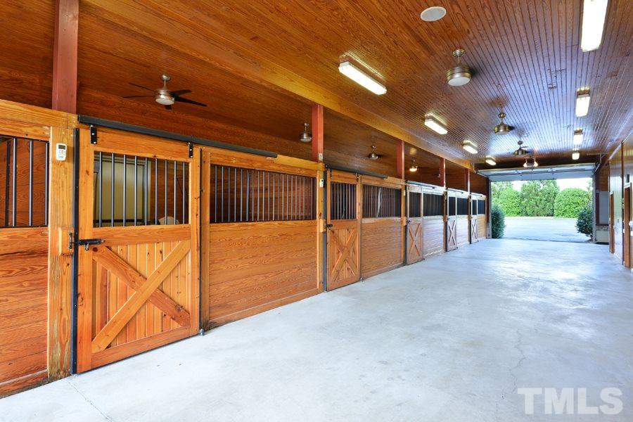7016 Holly Ridge Road Rougemont, NC 27572 - Photo 3 of 24 Six immaculate stalls open to 3 paddocks. There is a large washing station at the end, a tack room, an electric car charging station, a utility room, and storage room with extra refrigeration and freezer. The end turn-around doubles as a helicopter pad.