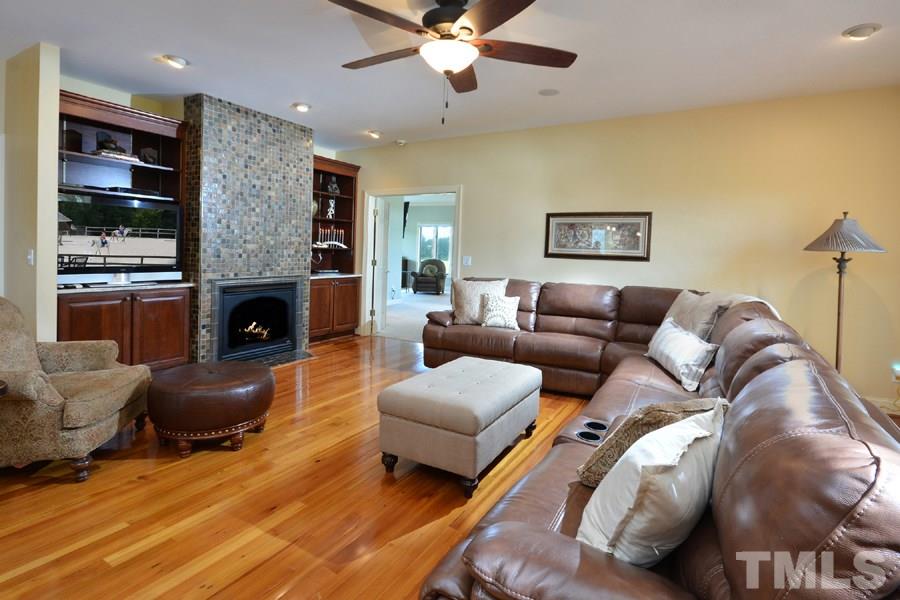 7016 Holly Ridge Road Rougemont, NC 27572 - Photo 10 of 24 The spacious family room has built in solid cherry cupboards and shelving around the remote controlled gas log fireplace. Rich multi-hued imported Italian tile surrounds the fireplace. The central living area includes the formal dining room and kitchen.