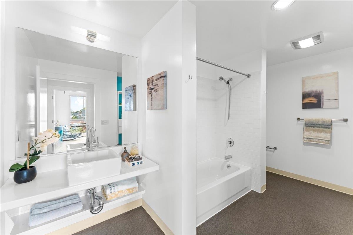 1201 Pine Street, Unit 365 Oakland, CA 94607 - Photo 15 of 33 a bathroom with a tub sink and mirror