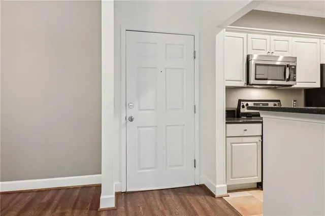 a kitchen with white cabinets and stainless steel appliances