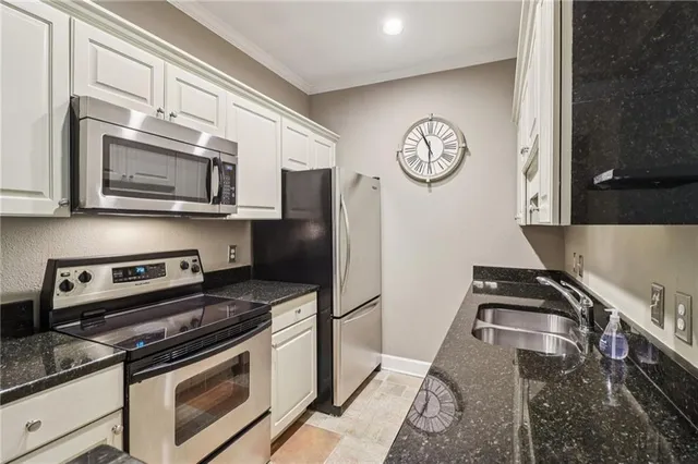 a kitchen with granite countertop stainless steel appliances a stove a microwave and a refrigerator