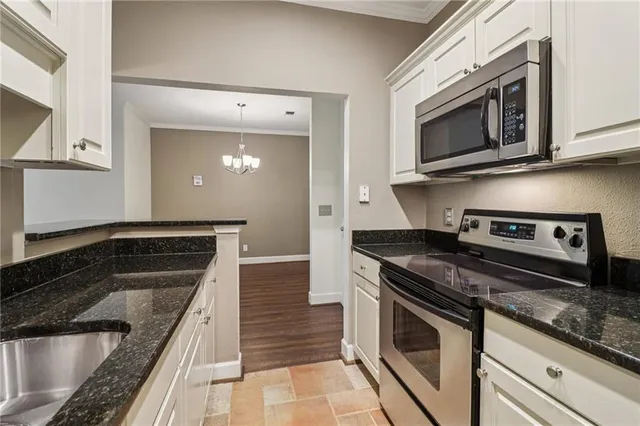 a kitchen with granite countertop a sink and stainless steel appliances