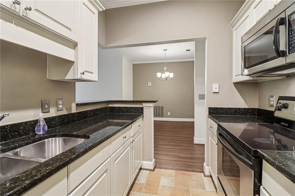 3071 Lenox Road Northeast, Unit 8 Atlanta, GA 30324 - Photo 17 of 50 a kitchen with granite countertop a sink and a stove top oven