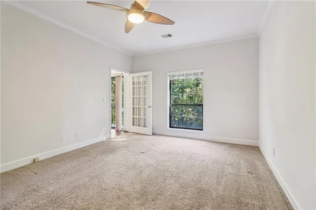 an empty room with windows and fan