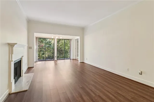 a view of a livingroom with wooden floor and a fireplace