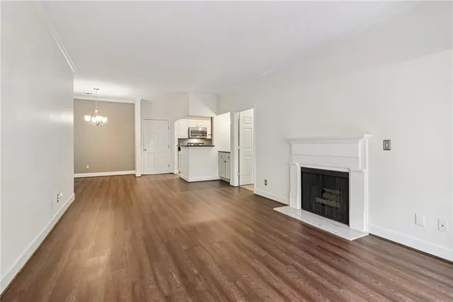 a view of empty room with a fireplace and wooden floor