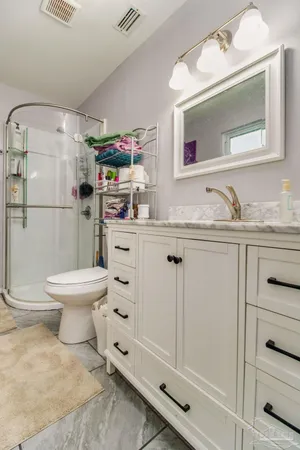 a bathroom with a granite countertop toilet sink and mirror