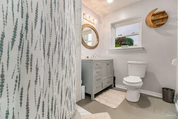 a bathroom with a toilet a sink and a mirror