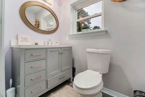 a bathroom with a toilet a sink and a mirror