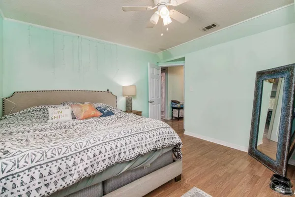 a bedroom with a bed and wooden floor