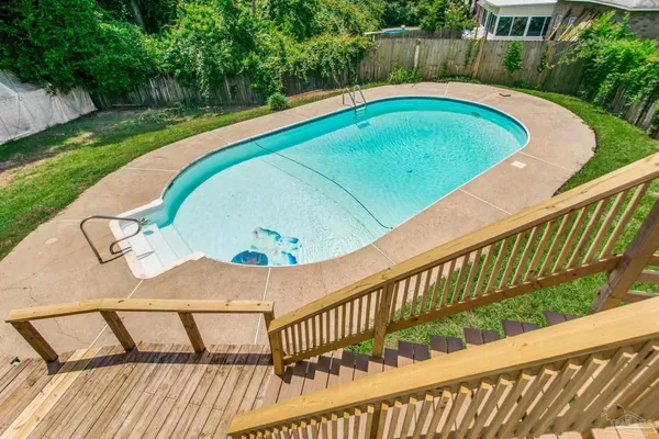 a view of a swimming pool with a patio and a garden
