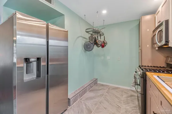 a view of a kitchen with a refrigerator and a sink