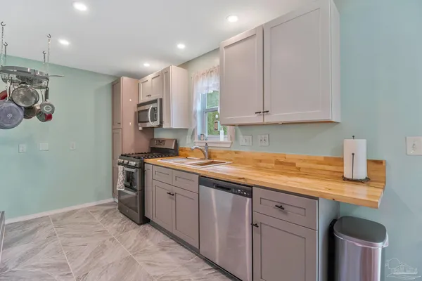 a kitchen with stainless steel appliances granite countertop a sink stove and cabinets