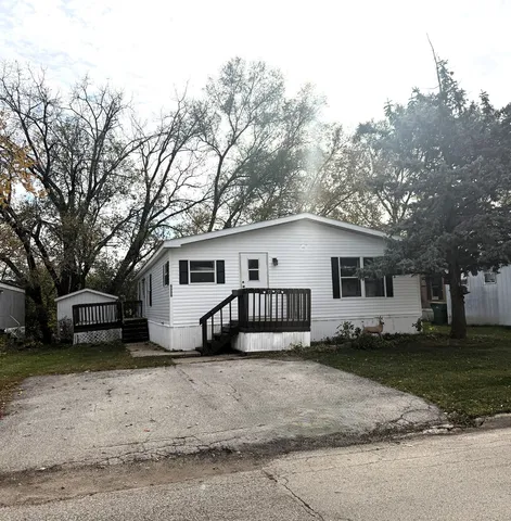 a view of a house with a big yard and large trees