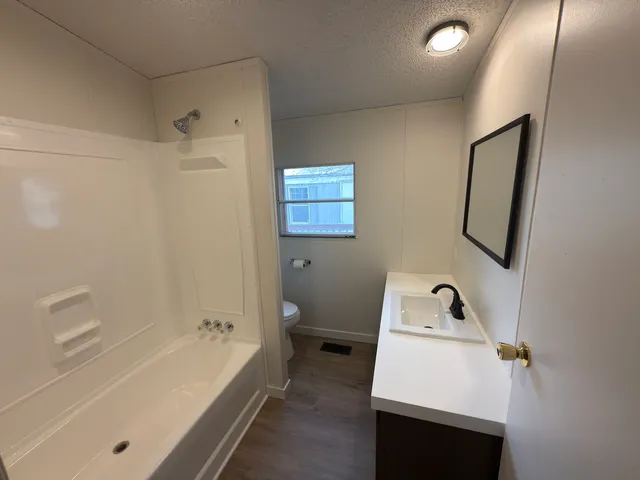 a bathroom with a tub sink and mirror