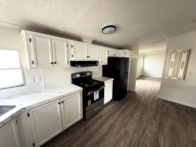 a kitchen with granite countertop a sink cabinets and stainless steel appliances