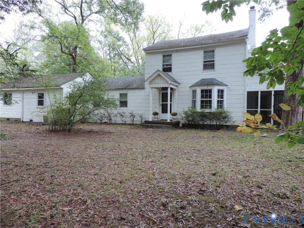 a front view of house with yard and trees around