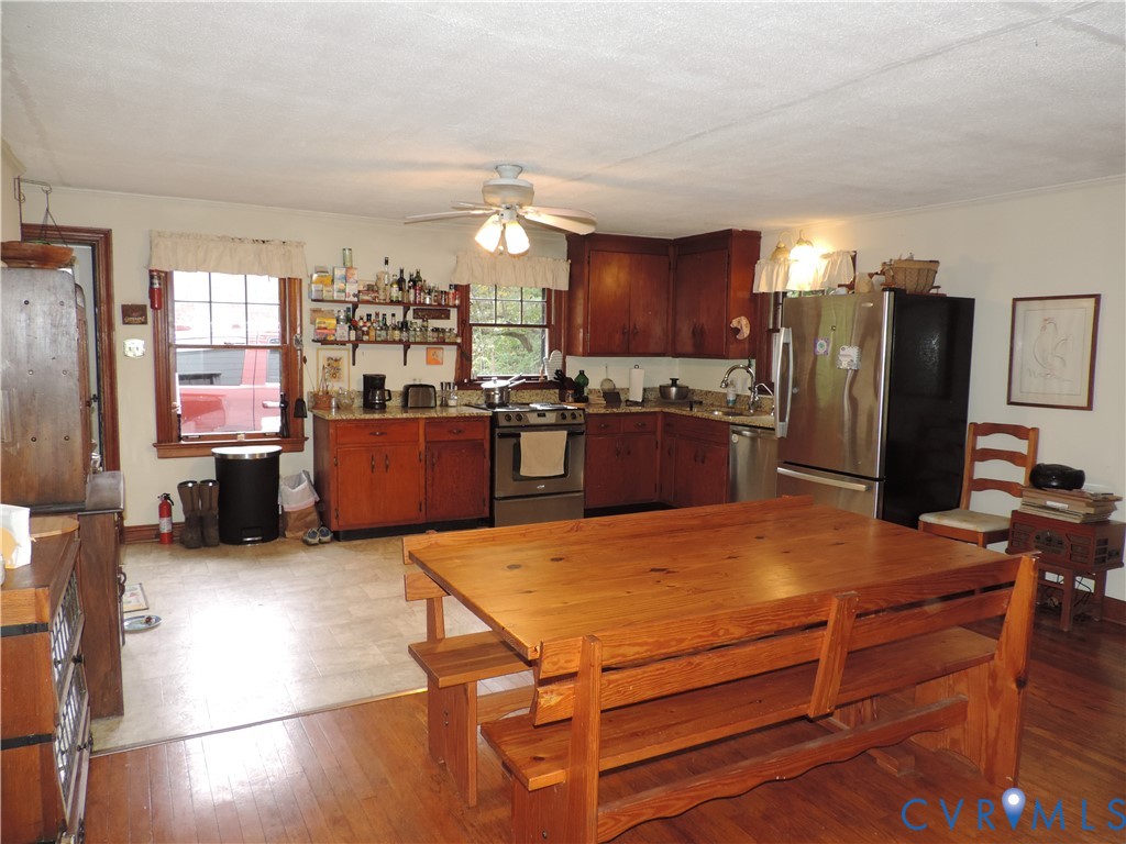 12262 Welling Hall Road Doswell, VA 23047 - Photo 2 of 42 a kitchen with stainless steel appliances wooden floor dining table and chairs