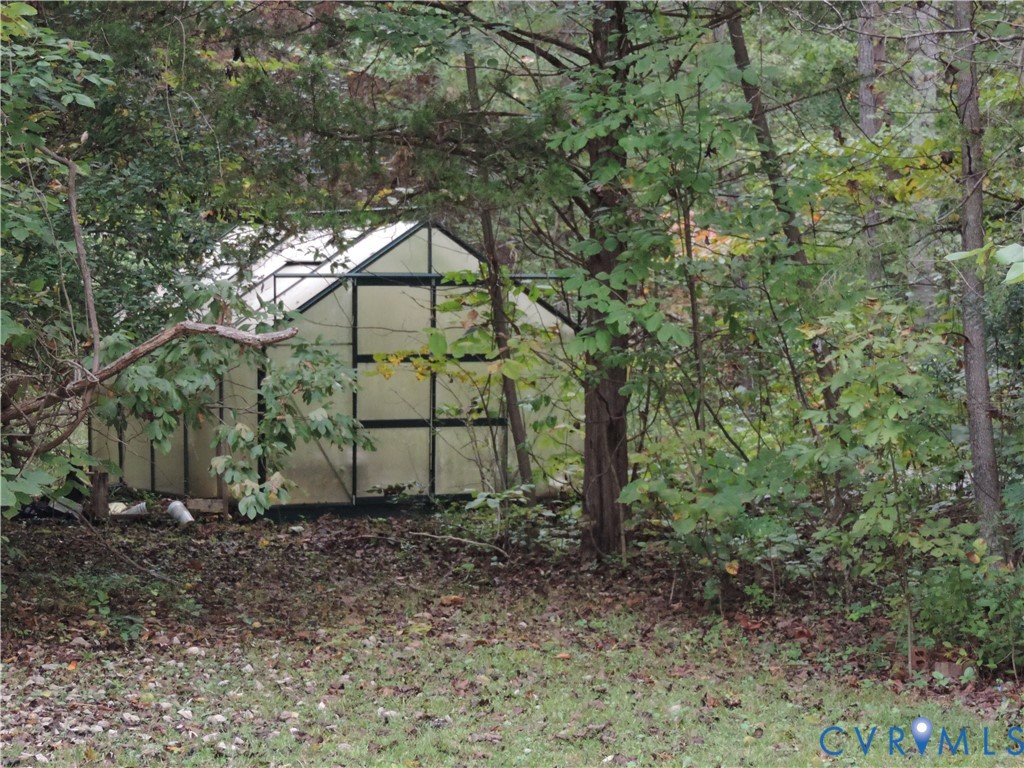 12262 Welling Hall Road Doswell, VA 23047 - Photo 42 of 42 a backyard of a house with lots of plants and large trees