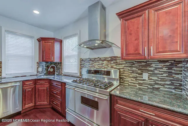 a kitchen with stainless steel appliances wooden cabinets and a stove top oven