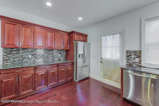 a kitchen with stainless steel appliances granite countertop a refrigerator sink and cabinets