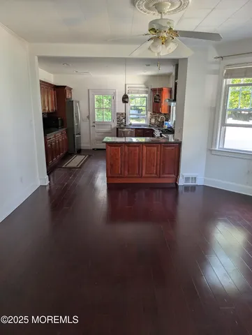 a living room with hard wood floors and a kitchen