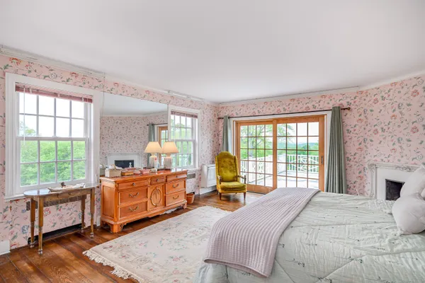 a bedroom with a bed and large windows