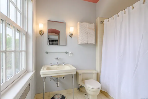 a bathroom with a sink toilet and mirror