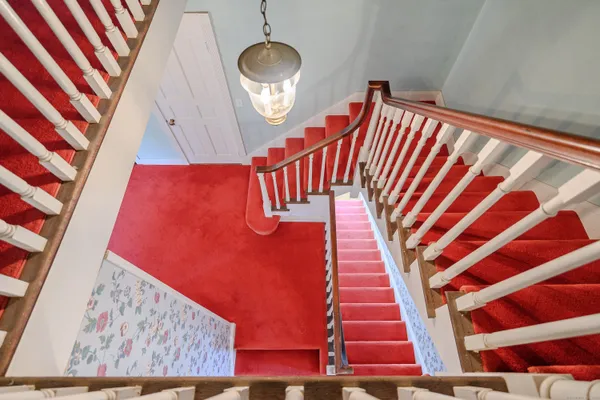 a hallway with stairs and a wooden floor