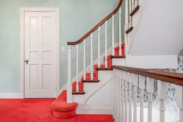 a hallway with stairs and a wooden floor
