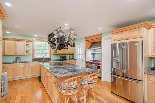 a kitchen with stainless steel appliances granite countertop a refrigerator and a sink