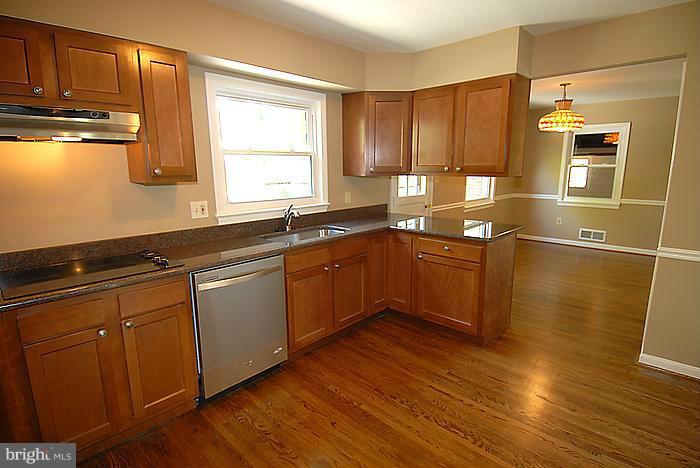 409 Highgate Terrace Silver Spring, MD 20904 - Photo 9 of 30 a kitchen with wooden floors and wooden cabinets