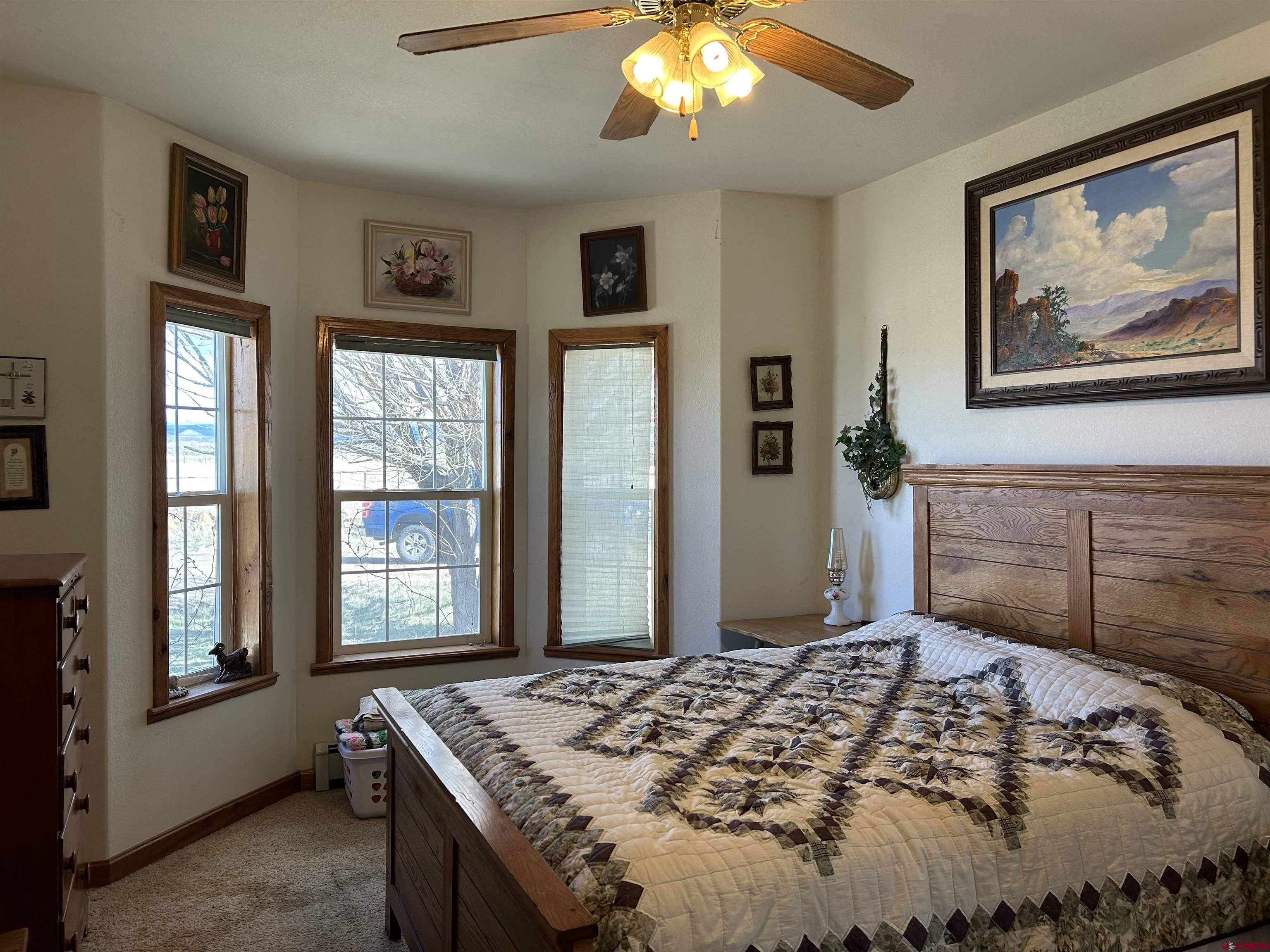 32116 Highway 145 Redvale, CO 81431 - Photo 14 of 28 a bedroom with a bed and a chandelier