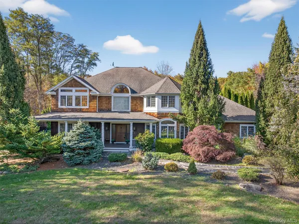 a front view of a house with a yard and lake view