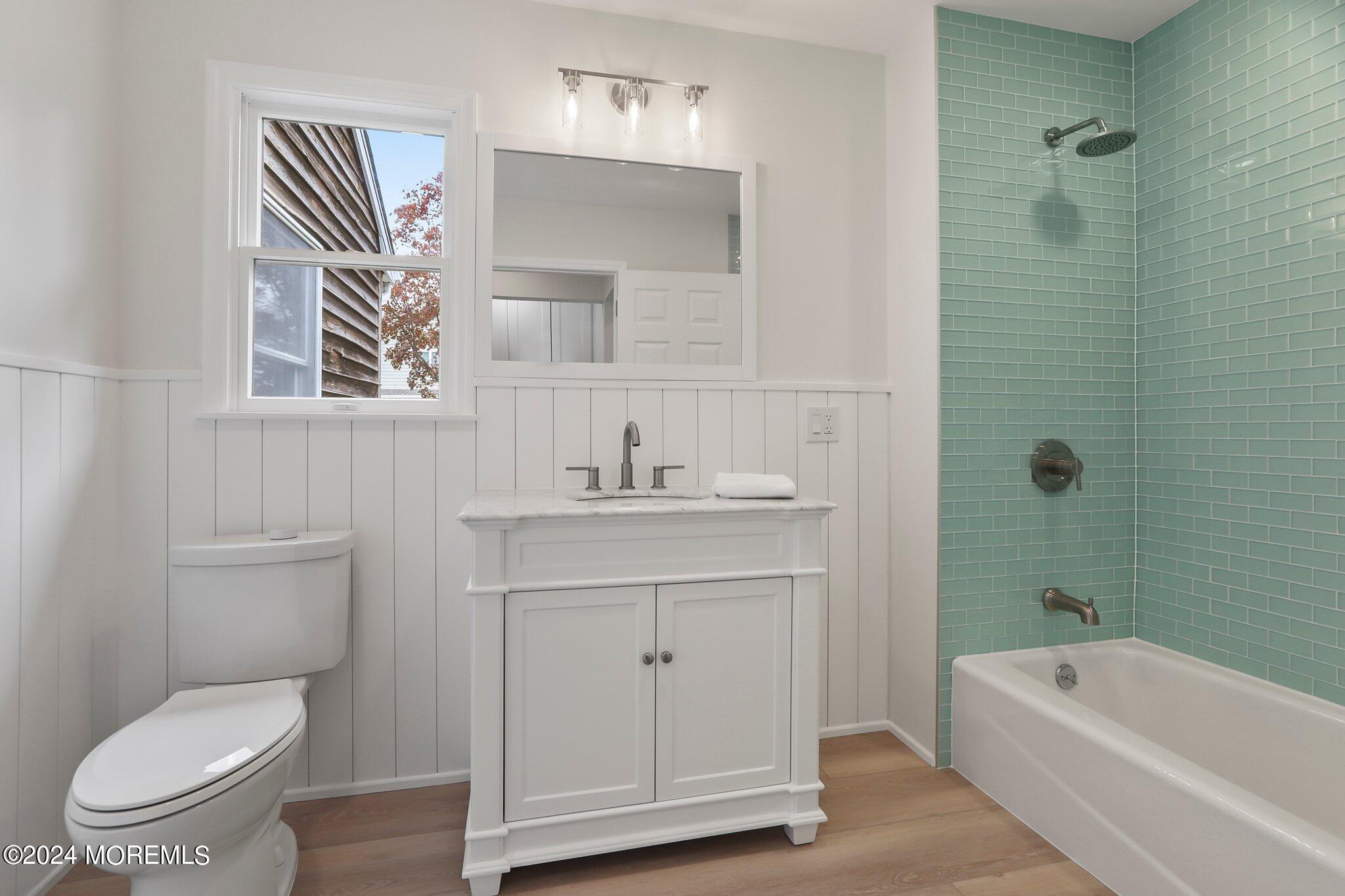 1419 Joseph Street Point Pleasant, NJ 08742 - Photo 14 of 27 a bathroom with a sink a toilet a mirror and bathtub