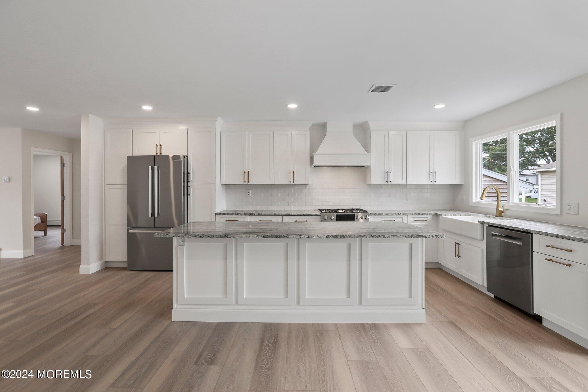 1419 Joseph Street Point Pleasant, NJ 08742 - Photo 7 of 27 a kitchen with stainless steel appliances granite countertop a stove a sink dishwasher and a refrigerator with wooden floor