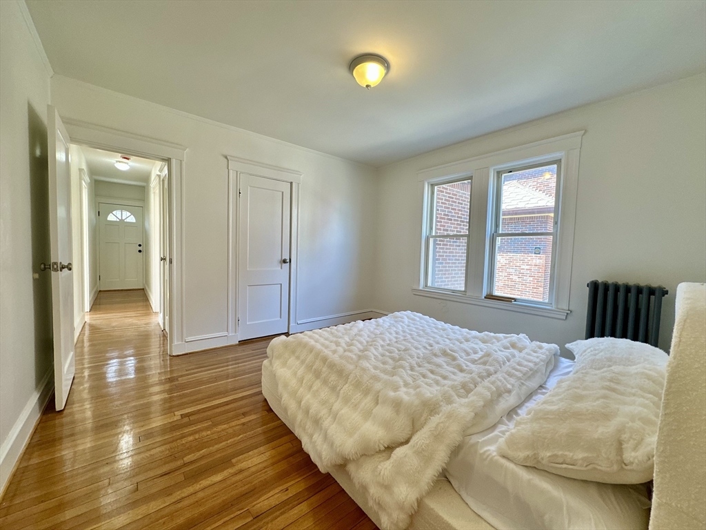 14 Hooper Street, Unit 1 Boston, MA 02124 - Photo 11 of 14 a spacious bedroom with a bed and wooden floor