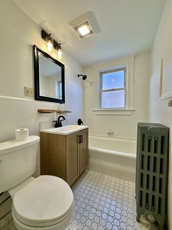 14 Hooper Street, Unit 1 Boston, MA 02124 - Photo 12 of 14 a bathroom with a toilet a sink a mirror a bathtub and a shower