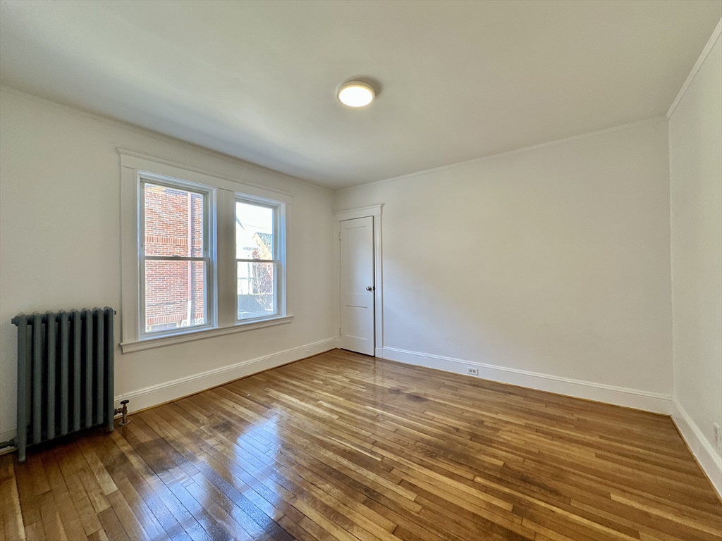 14 Hooper Street, Unit 1 Boston, MA 02124 - Photo 13 of 14 a view of an empty room with wooden floor and a window