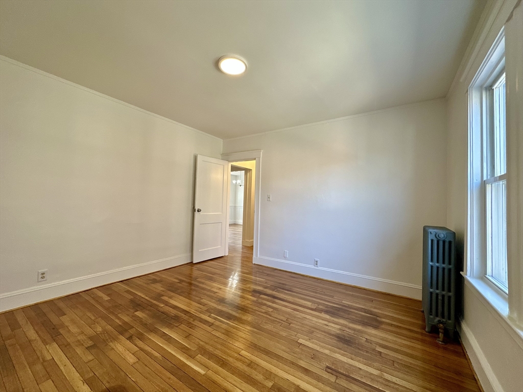 14 Hooper Street, Unit 1 Boston, MA 02124 - Photo 14 of 14 a view of an empty room with wooden floor and a window