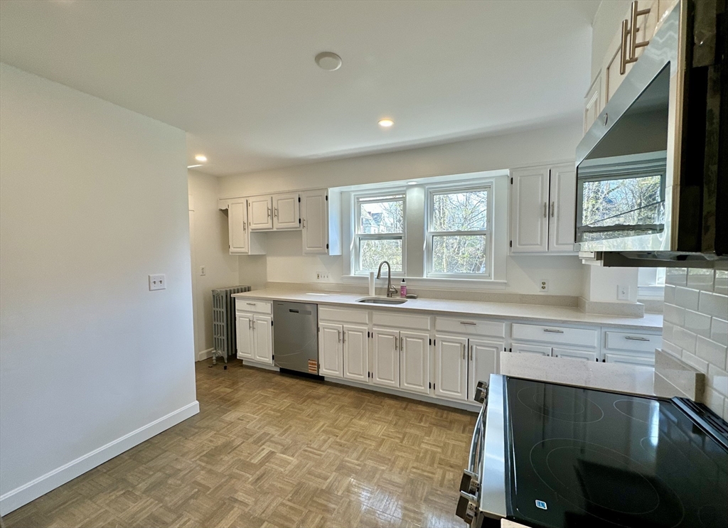 14 Hooper Street, Unit 1 Boston, MA 02124 - Photo 2 of 14 a kitchen with granite countertop a sink cabinets stainless steel appliances and a window
