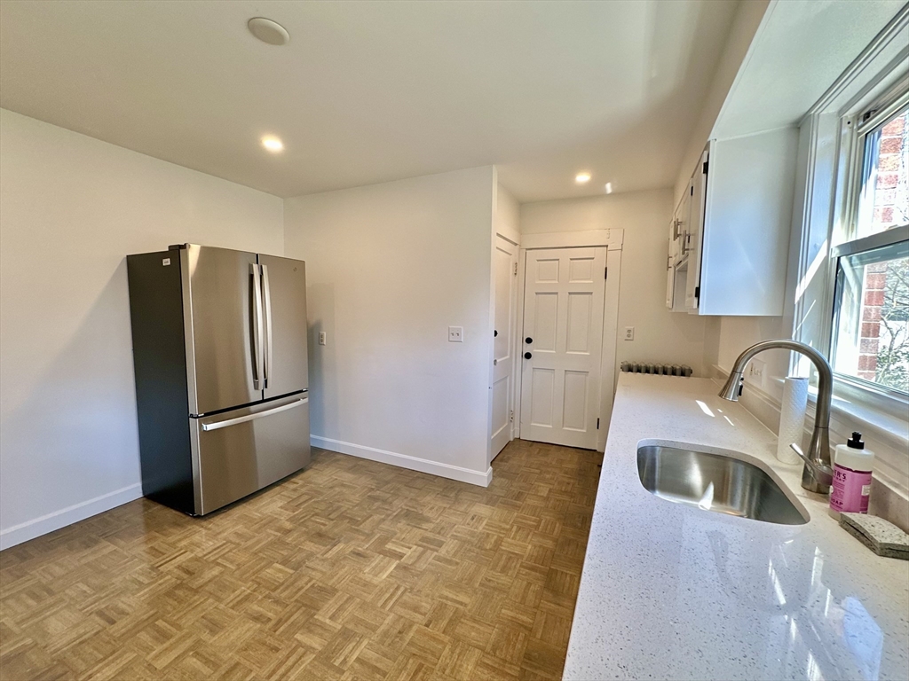 14 Hooper Street, Unit 1 Boston, MA 02124 - Photo 3 of 14 a kitchen with granite countertop a refrigerator and a sink