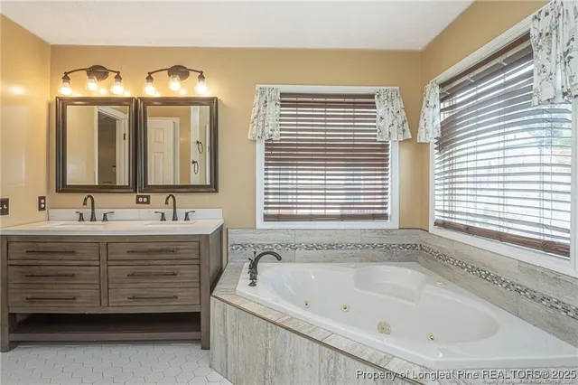 a bathroom with a bathtub sink and mirror
