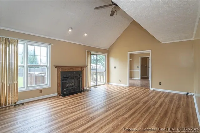 wooden floor fireplace and windows in an empty room