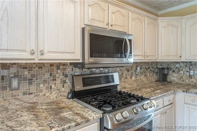 a kitchen with granite countertop white cabinets stainless steel appliances and a sink
