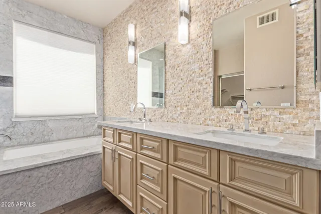 a bathroom with a granite countertop sink and a bathtub