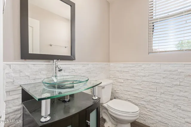 a bathroom with a toilet a sink and a mirror
